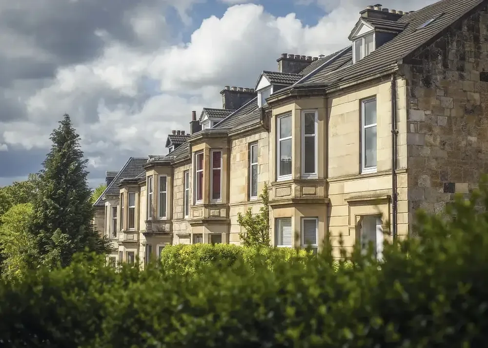 A terrace of stone-fronted houses behind trees